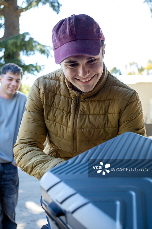 青少年朋友将行李箱装入车内准备旅行图片素材