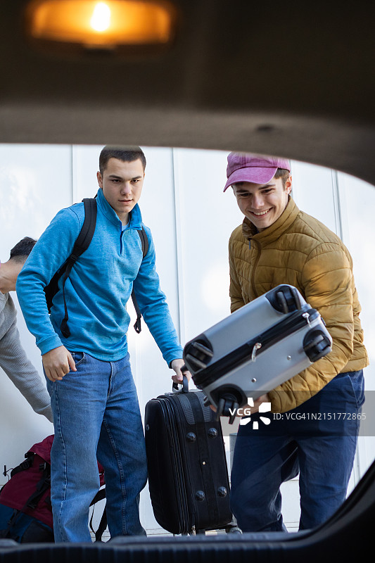 青少年朋友将行李箱装入车内准备旅行图片素材