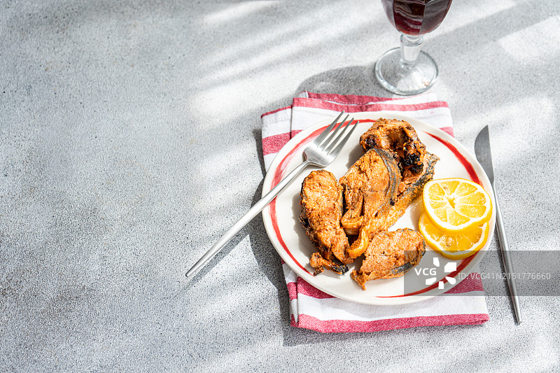 烤鳟鱼牛排配柠檬片和红酒杯特写图片素材