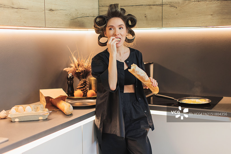 金发复古发型女子在厨房做饭，妻子吃法棍面包，趣味图片素材