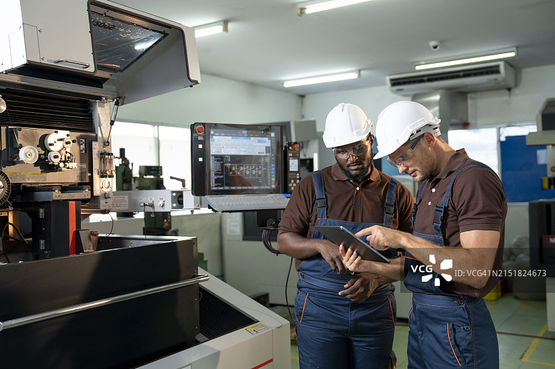 两名工程师在机械厂讨论工作图片素材
