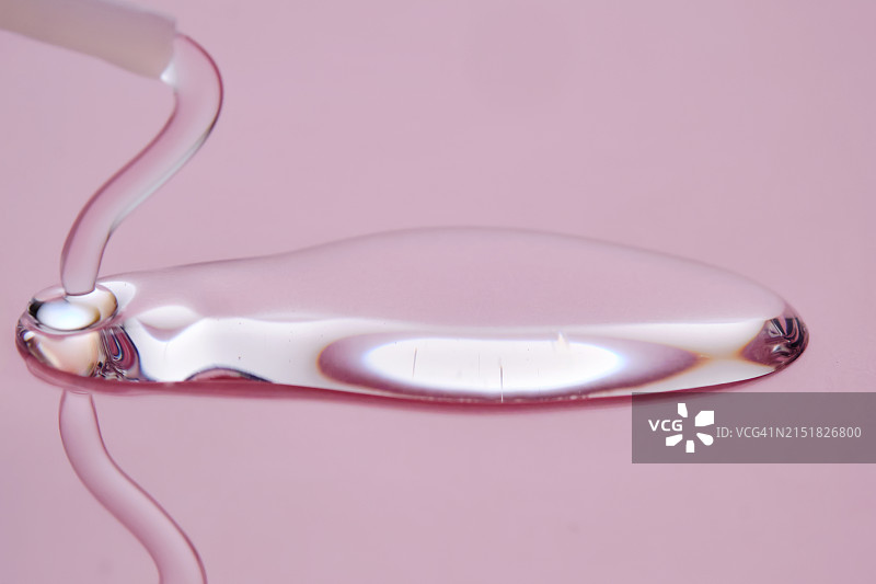 粉色背景上的滴落护肤品图片素材