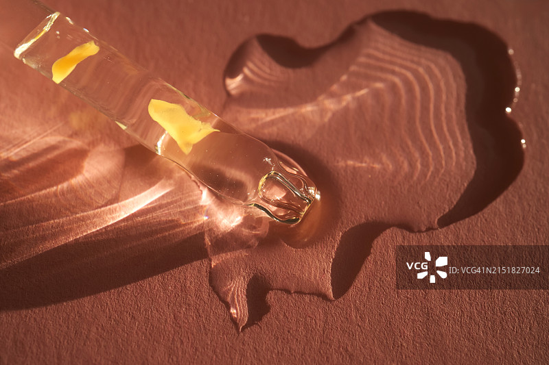 移液器滴出精华液，粉色背景图片素材