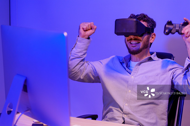 男人在家戴VR眼镜用遥控器操控小型无人机图片素材