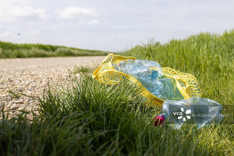 躺在黄色可重复使用袋子里的塑料空瓶图片素材