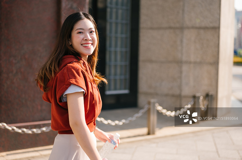 年轻女性在京都盐小路通的傍晚漫步，感受日本文化和繁忙的交通图片素材