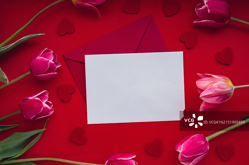 俯视拍摄：桌子上带有玫瑰花瓣和心形的空白纸张图片素材