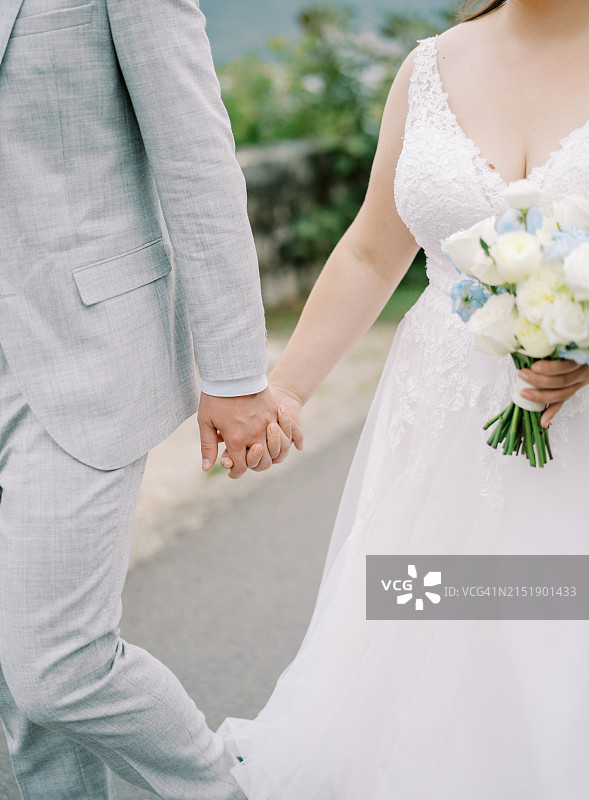 在湖边手牵手的新婚夫妇图片素材