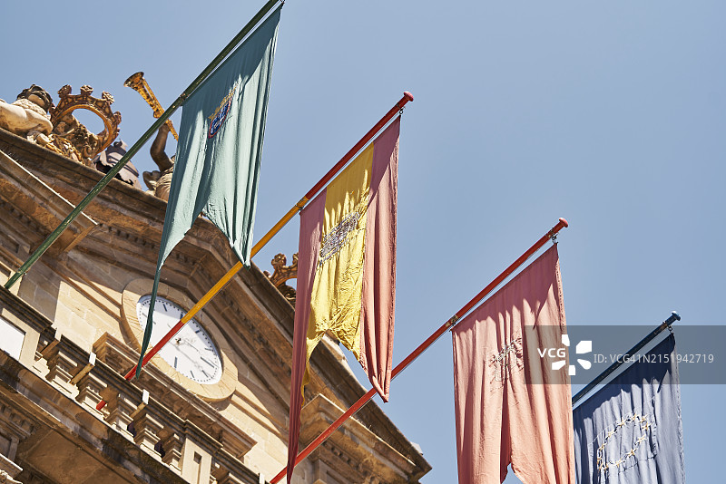 潘普洛纳市政厅阳台外的金属杆上的旗帜（仰视侧视）图片素材
