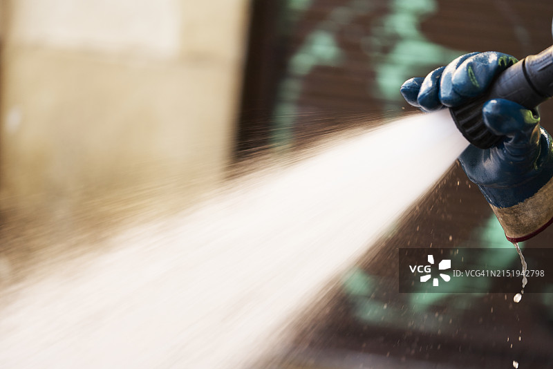 手持软管喷射水流特写图片素材