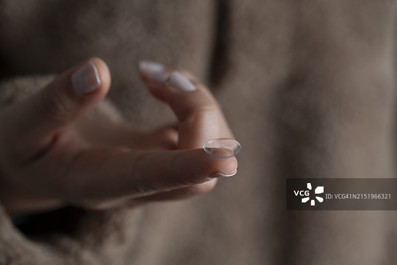 女人用手指拿着隐形眼镜图片素材