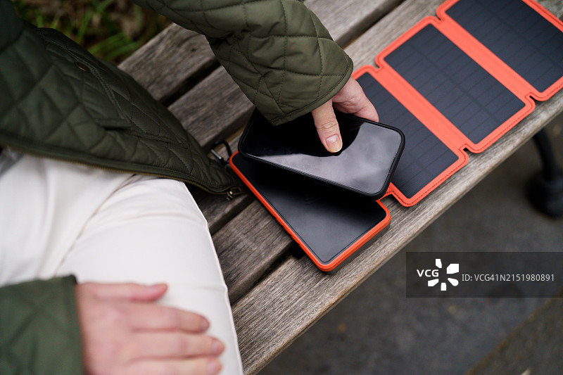 使用便携式太阳能充电器的女人图片素材