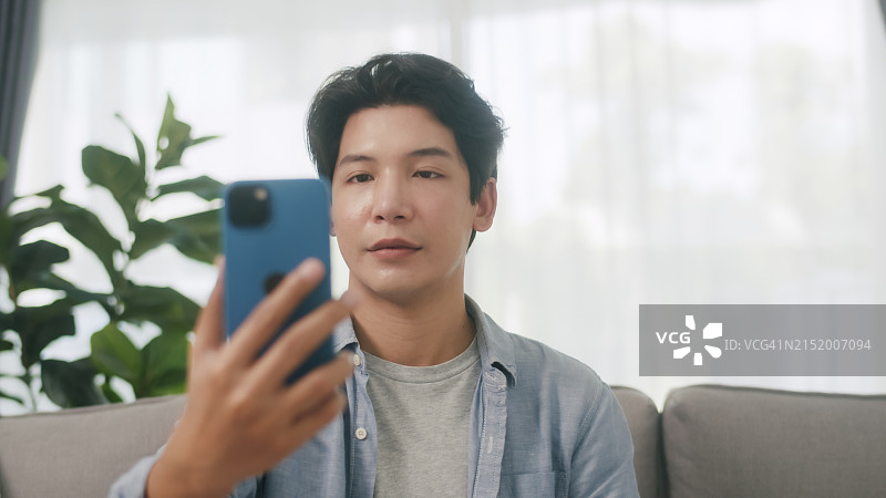 亚洲男人用智能手机进行面部识别图片素材