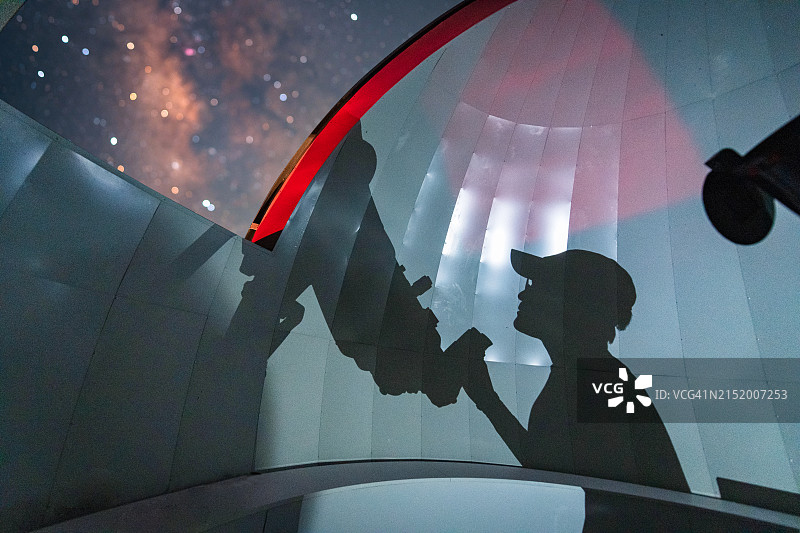 在天文望远镜圆顶中检查设置的天文学家图片素材