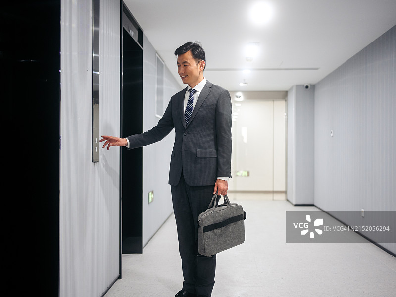 商务男人在商务楼里等电梯图片素材
