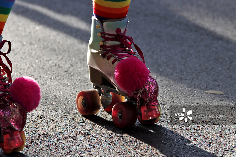 女孩在阳光明媚的日子里沿着街道滑旱冰图片素材
