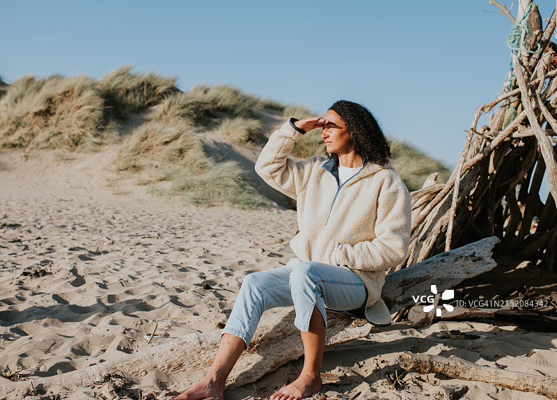 海滩上用手遮阳的美丽女人图片素材