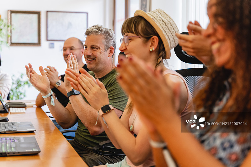 一群商务人士在办公室的办公桌前鼓掌图片素材