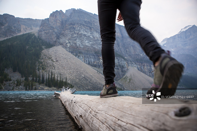 在梦莲湖附近徒步旅行时，在原木上保持平衡的女人图片素材