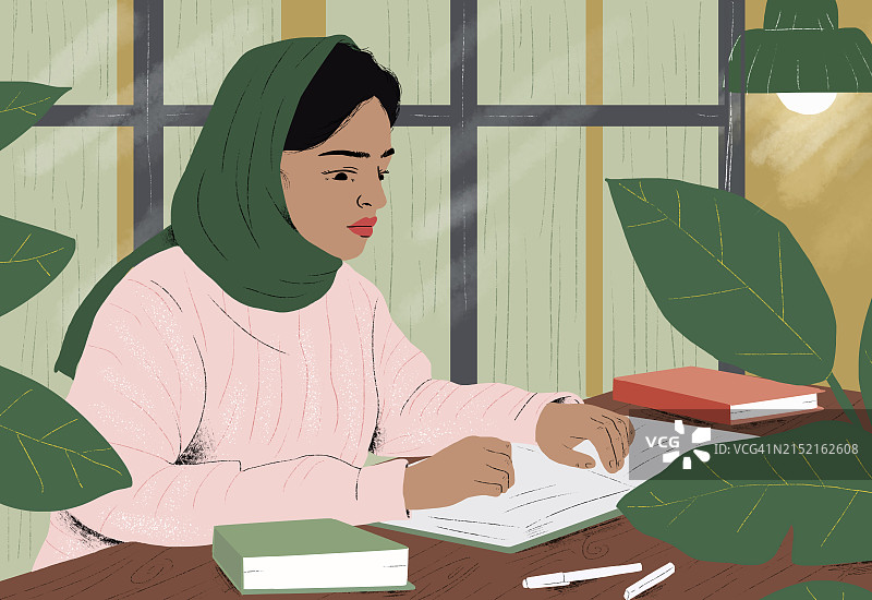 戴着头巾的女人在家读书图片素材