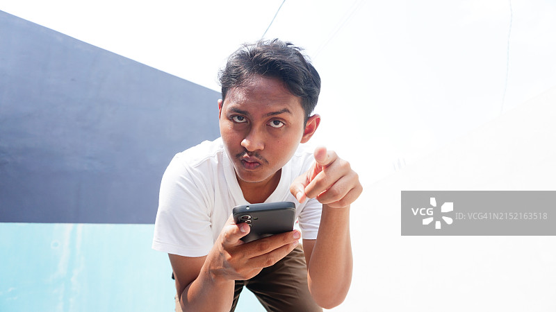 低角度拍摄指向相机的男人图片素材