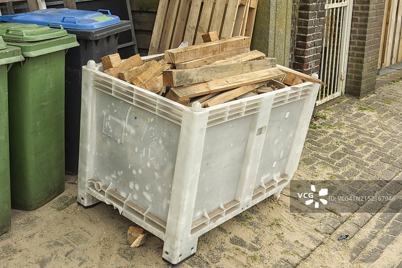 街边的开放式塑料垃圾箱，装满了废木材图片素材