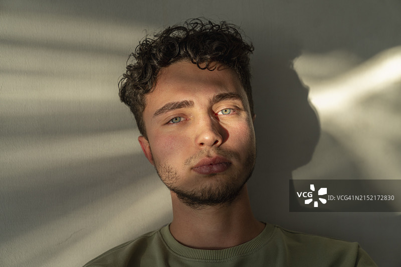 年轻男子倚靠墙壁图片素材