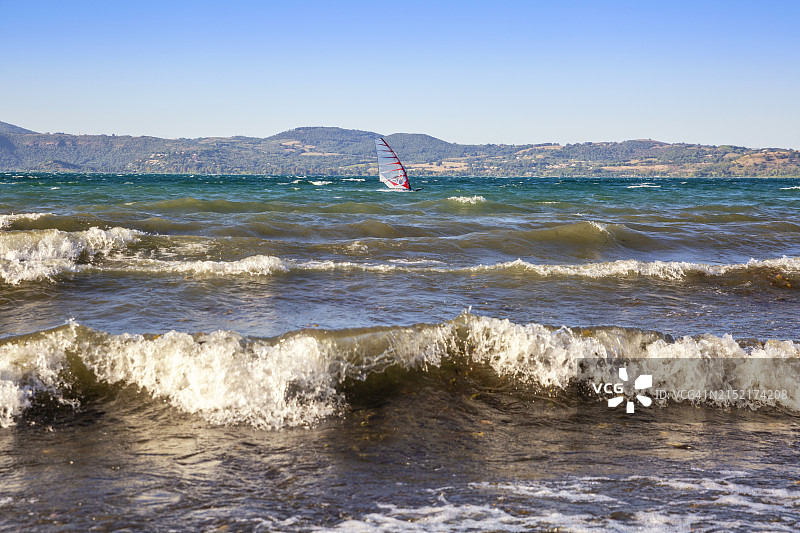 意大利拉齐奥安圭拉拉萨巴齐亚：布拉恰诺湖上的波浪和帆板图片素材