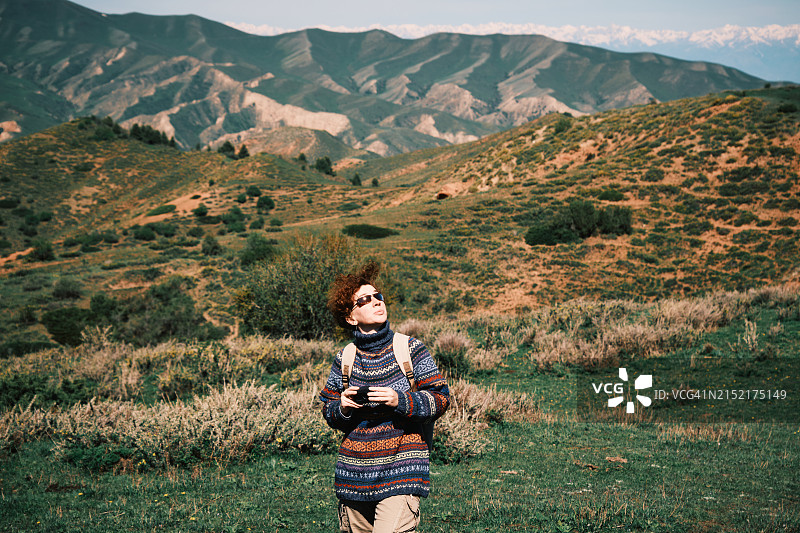 快乐的女人在春天拍摄山区图片素材