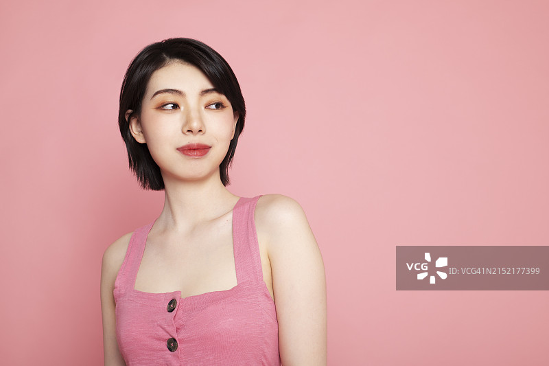 面带微笑的短发女人，背景为粉红色图片素材