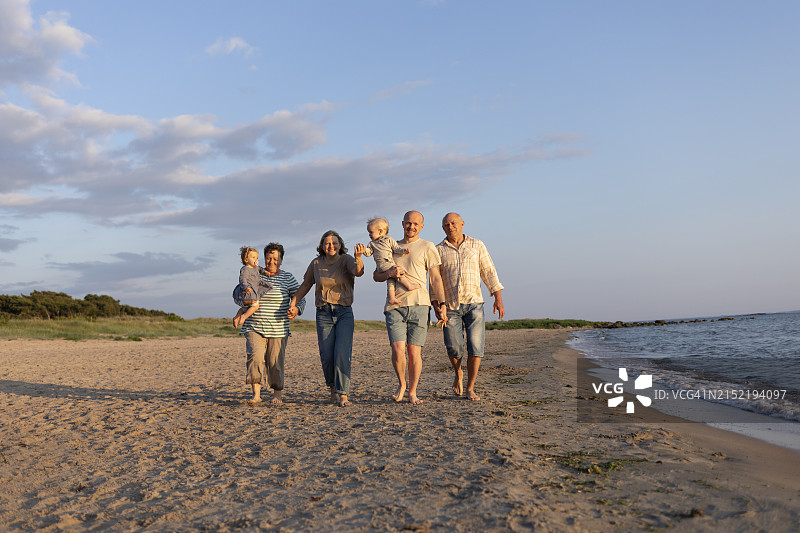 在沙滩上牵手行走的多代同堂家庭图片素材