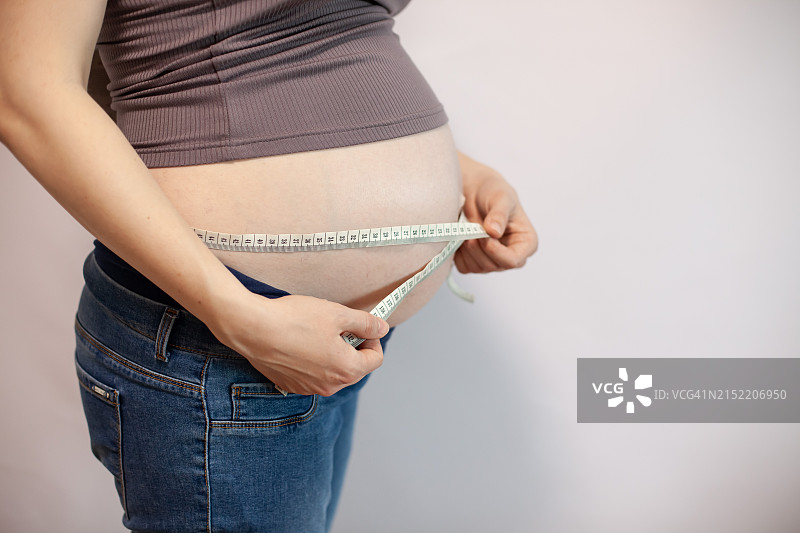 孕妇用卷尺测量腰围图片素材