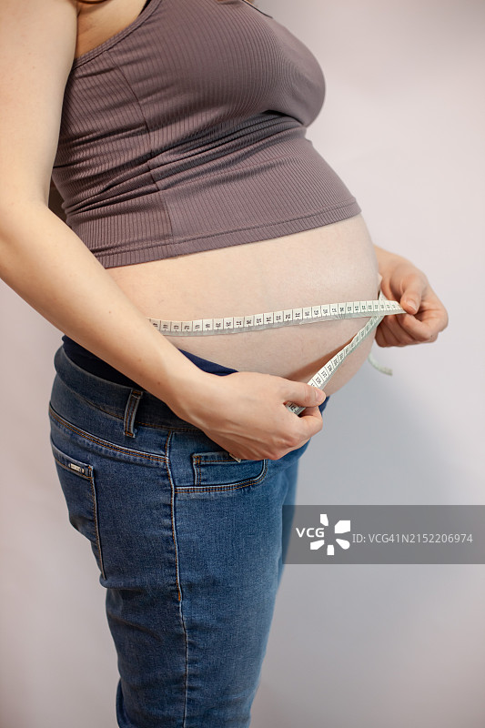 孕妇用卷尺测量腰围图片素材