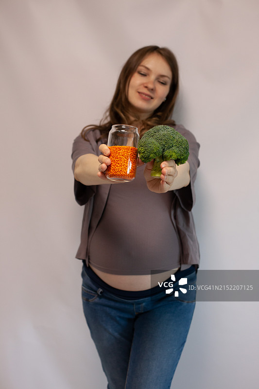 怀孕27-29周，手中拿着西兰花和扁豆图片素材