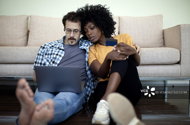 幸福情侣使用信用卡和笔记本电脑图片素材