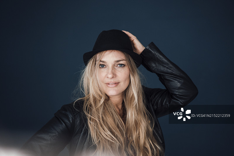 戴帽子的金发中年妇女，彩色背景图片素材