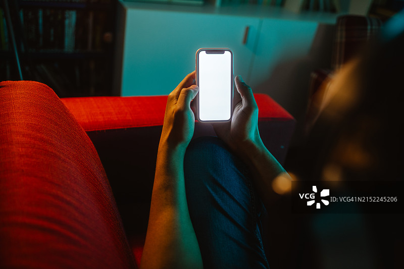 在家手持空白屏幕智能手机图片素材