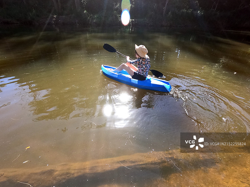 年轻的澳大利亚女孩在河上划皮艇图片素材