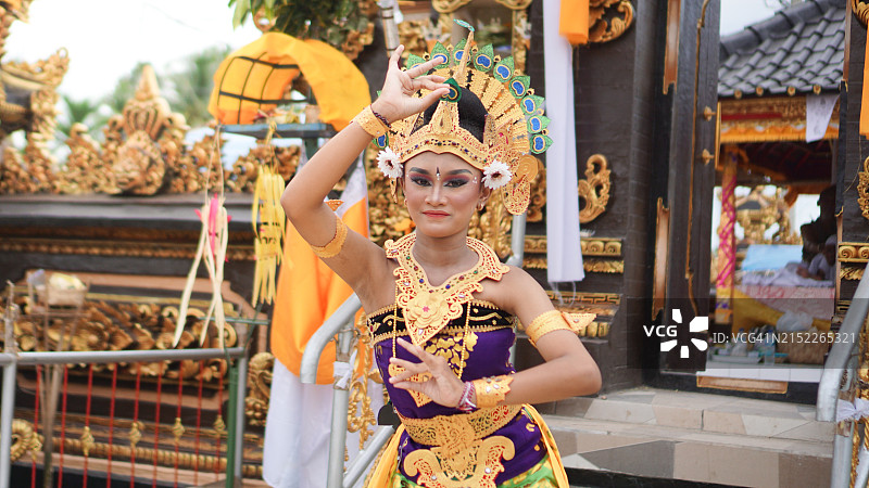 巴厘岛女孩舞蹈手势：孔雀天使，身着孔雀服饰，巴厘岛寺庙背景图片素材