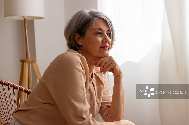 望向窗外沉思的年长女人图片素材