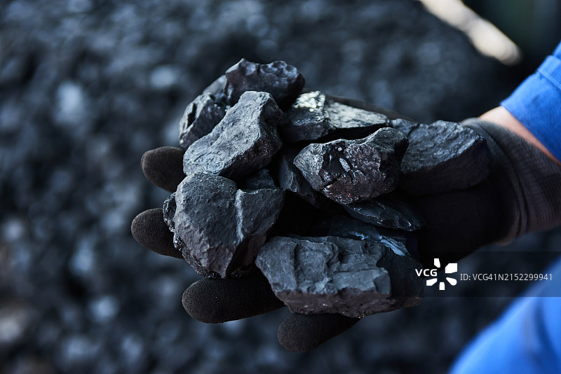 拿着一块煤炭的人图片素材
