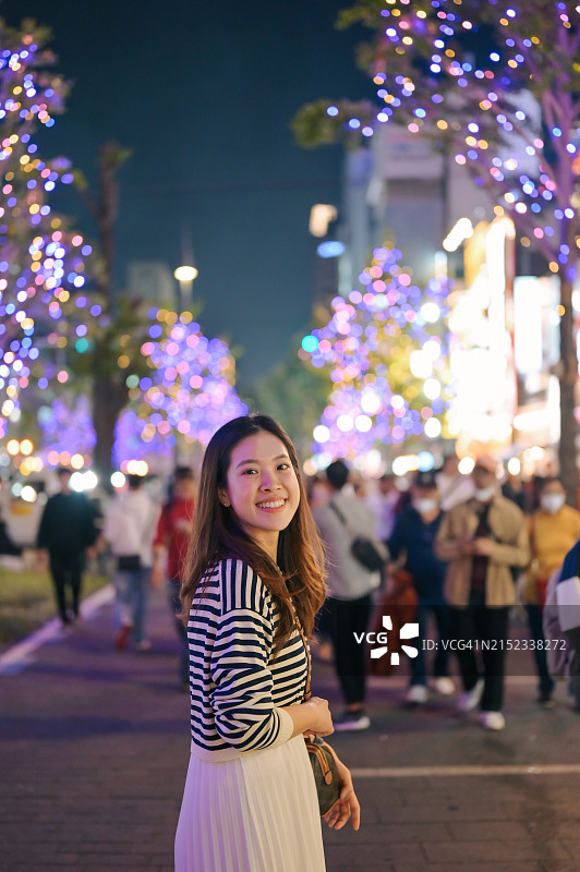 游客在大阪御堂筋街道的城市交通中观赏大阪御堂筋彩灯的竖版照片图片素材