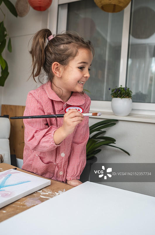 快乐的小女孩用水彩绘画的照片图片素材