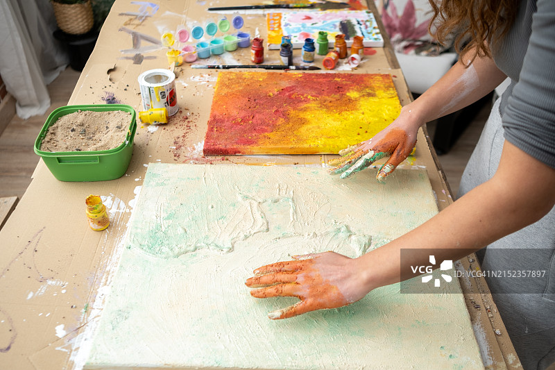 可爱的女艺术家展示她用绘画弄脏的双手图片素材