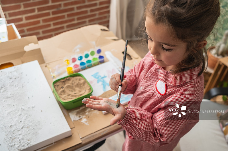 可爱的小女孩在家用彩色颜料绘画图片素材