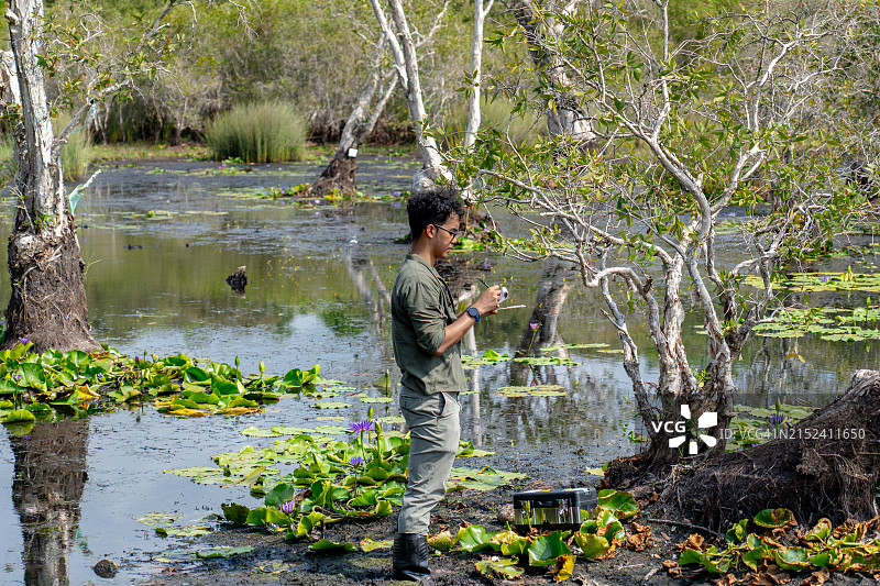 中年亚洲生物学家在国家植物园沼泽地记录植物种类图片素材