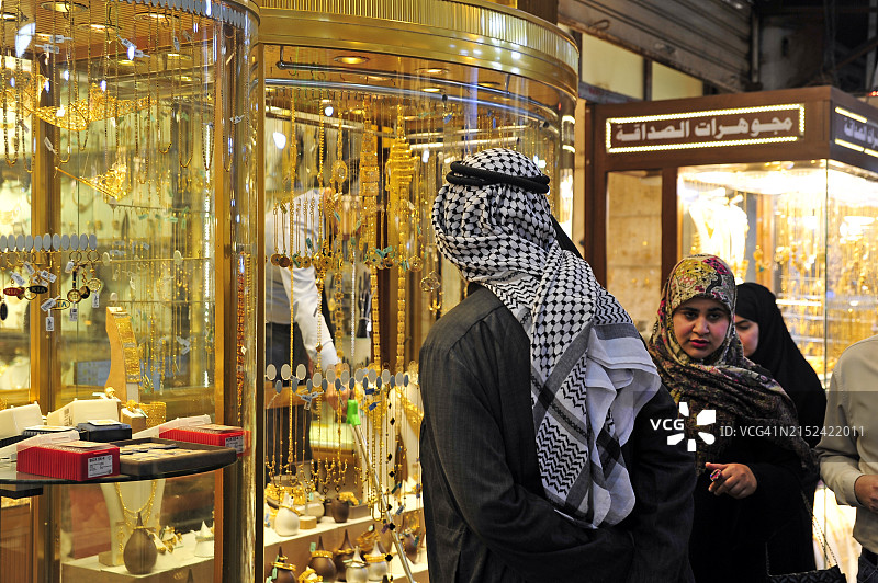 伊拉克经济现状：伊拉克家庭在伊拉克巴格达一家珠宝店橱窗前观看图片素材