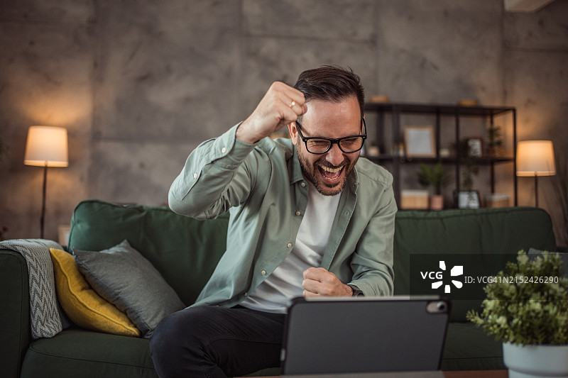 中年男人在家使用平板电脑图片素材