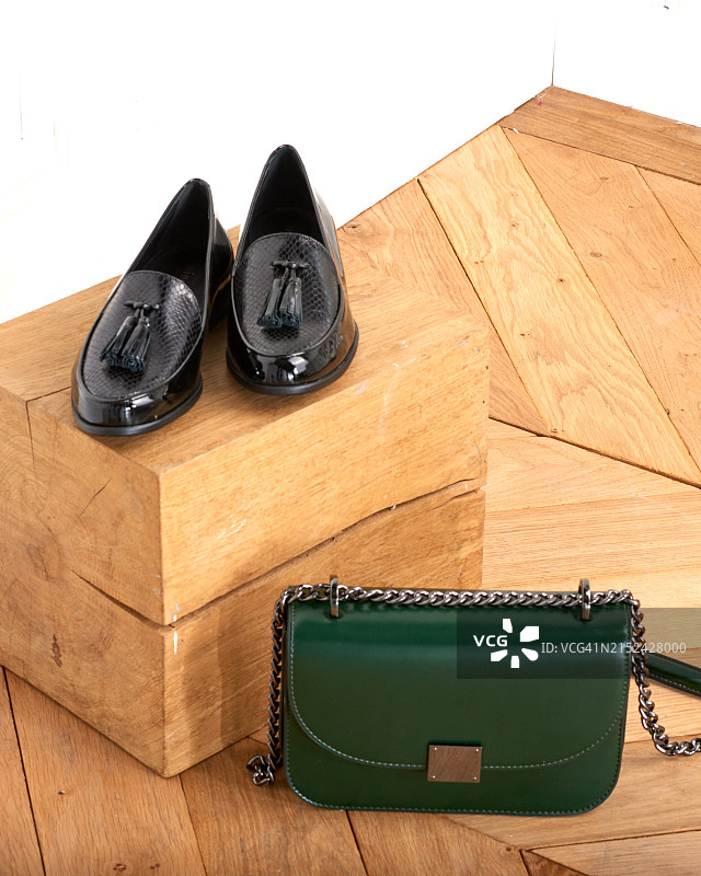 带流苏的黑色皮革学院风鞋和绿色皮革手提包图片素材