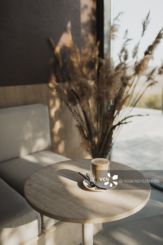 大理石桌面上装满拿铁或卡布奇诺的耐热双层玻璃杯图片素材